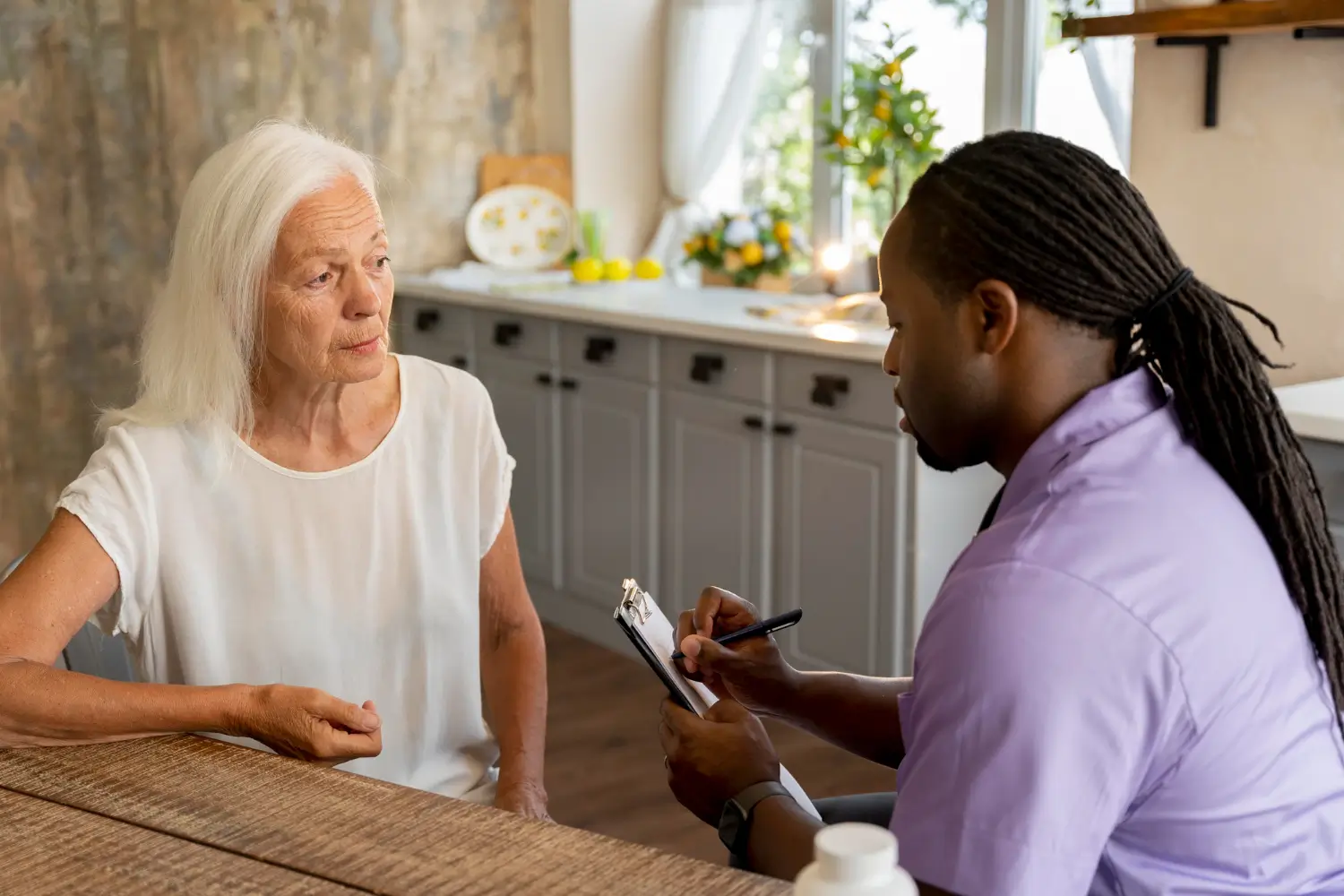 Concierge professional discussing household needs with an older woman during a personalized home support visit in Dover, Delaware.