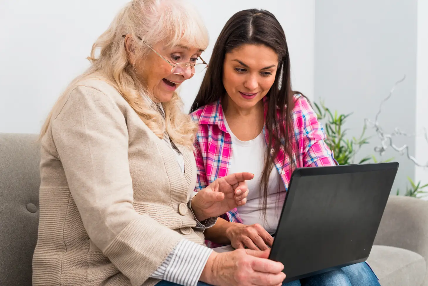 Personal concierge helping an older woman use a laptop through patient senior technology assistance in Dover, Delaware.