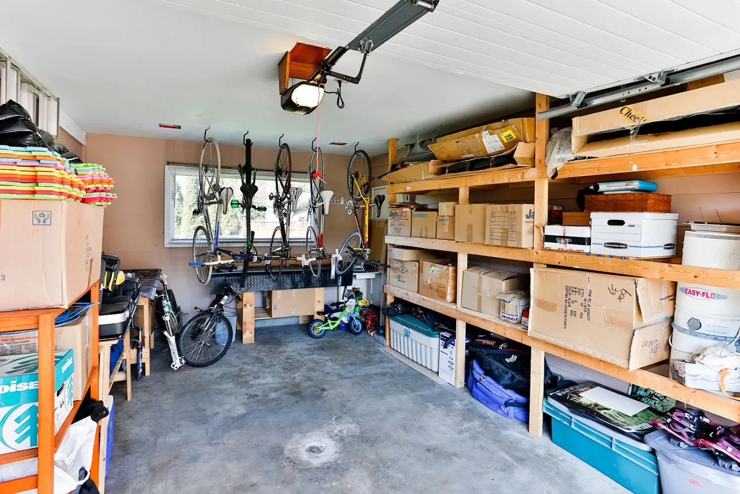 Clean and neatly arranged garage with organized shelves, storage bins and tools as part of garage organizing services in Dover, Delaware.
