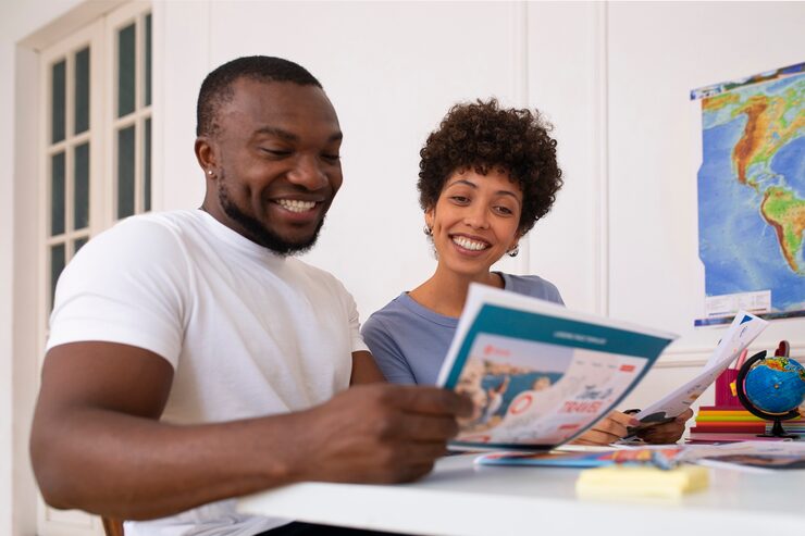 Couple reviewing travel brochures and planning details with concierge-style travel assistance in Dover, Delaware.