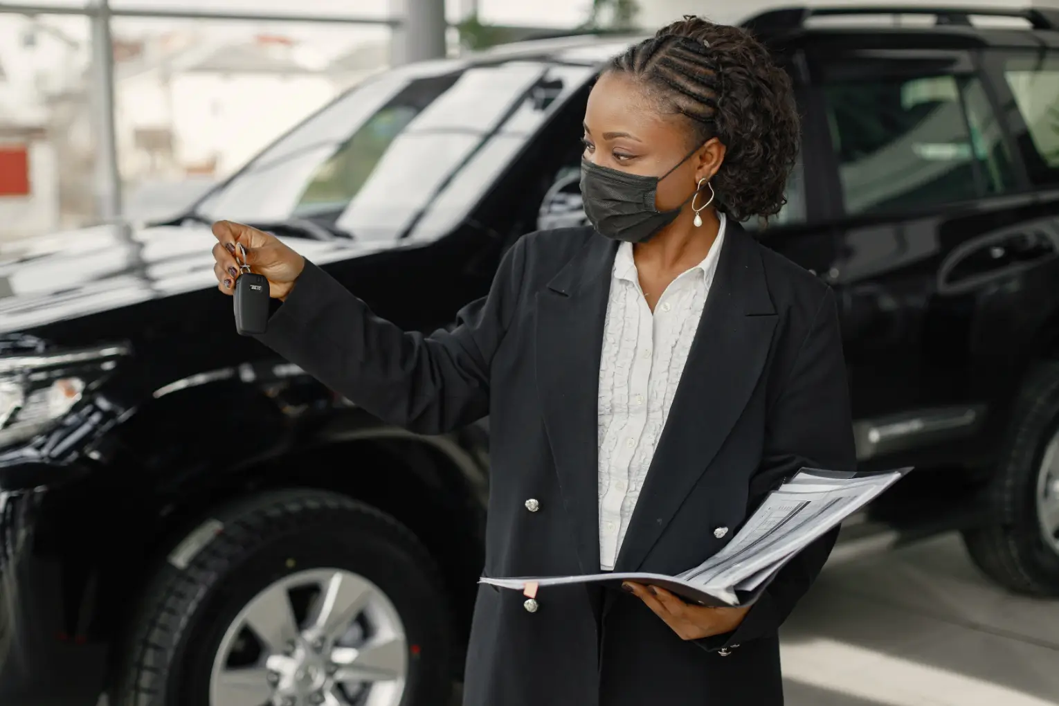Concierge professional coordinating vehicle services and holding car keys at an auto dealership in Dover, Delaware.