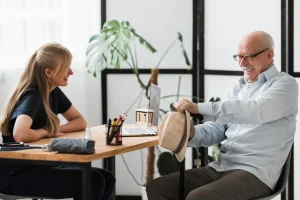 Personal concierge speaking with an older man during a supportive visit, illustrating how senior concierge services promote independence and peace of mind in Dover, Delaware.