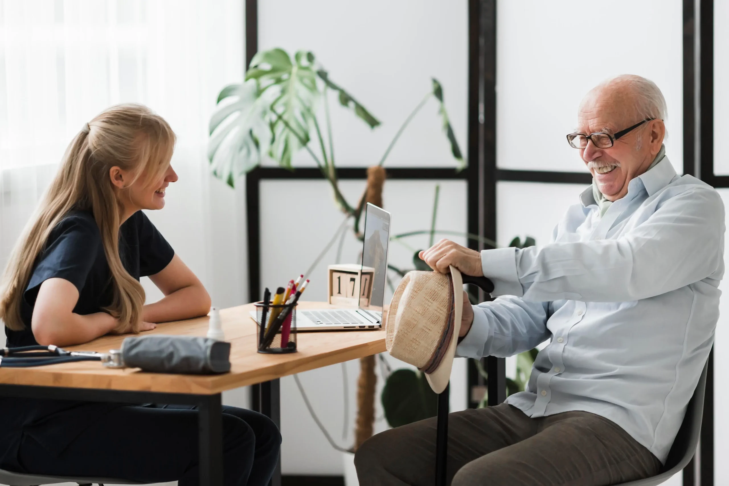 Personal concierge speaking with an older man during a supportive visit, illustrating how senior concierge services promote independence and peace of mind in Dover, Delaware.